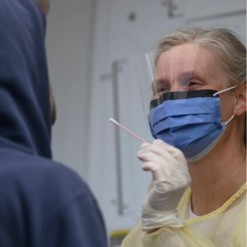 Nurse doing a covid swab on a patient in the mobile van